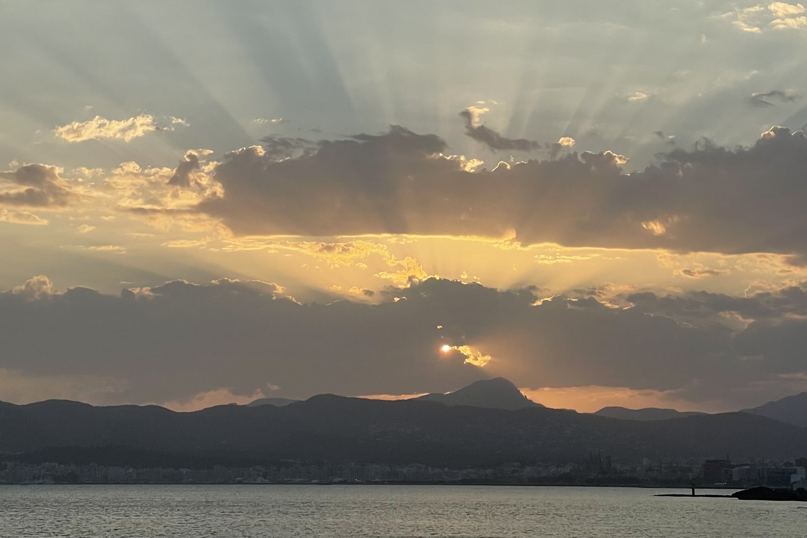 Sonne über dem Meer mit Lichtstrahlen durch die Wolken